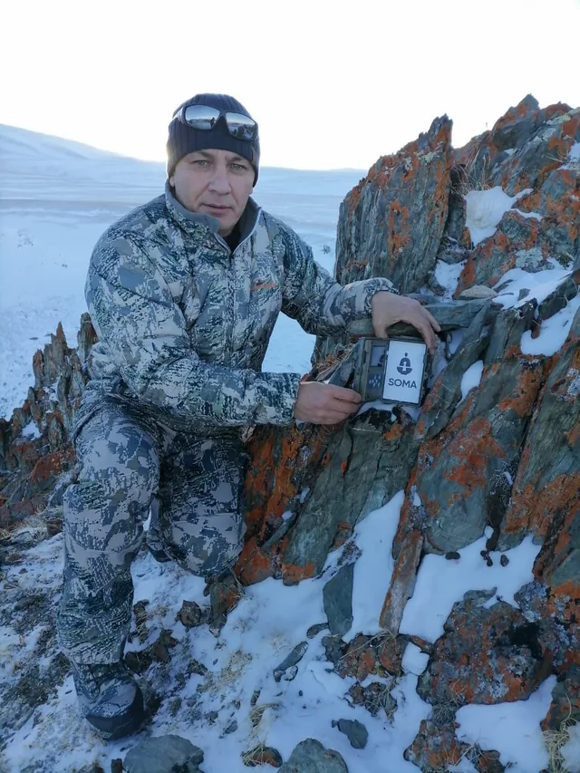 Инспектор Сайлюгемского национального парка ставит фотоловушку с табличкой SOMA