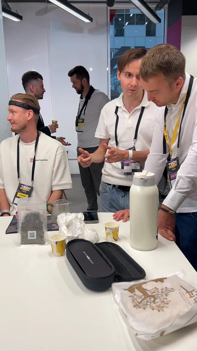 Замер альфа-волн на Tech Week: гость в обруче-датчике за чайным столом SOMA, рядом команда